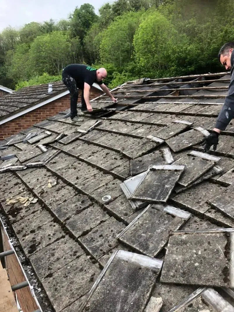 Gutter being cleared of moss and debris at a house in Frimley